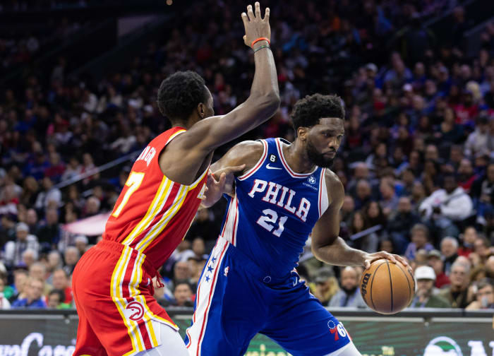 76ers center Joel Embiid dribbles past Hawks forward Onyeka Okongwu.